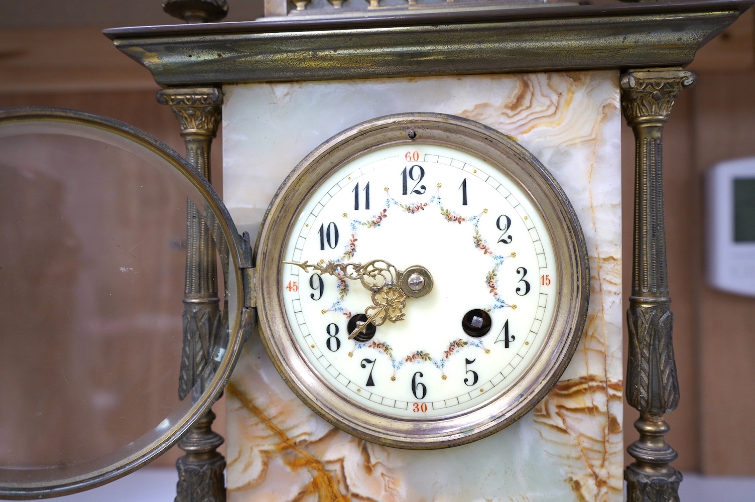 An early 20th century marble and onyx mantel clock with enamel dial with pendulum, no key, 32cm high. Condition - fair, untested